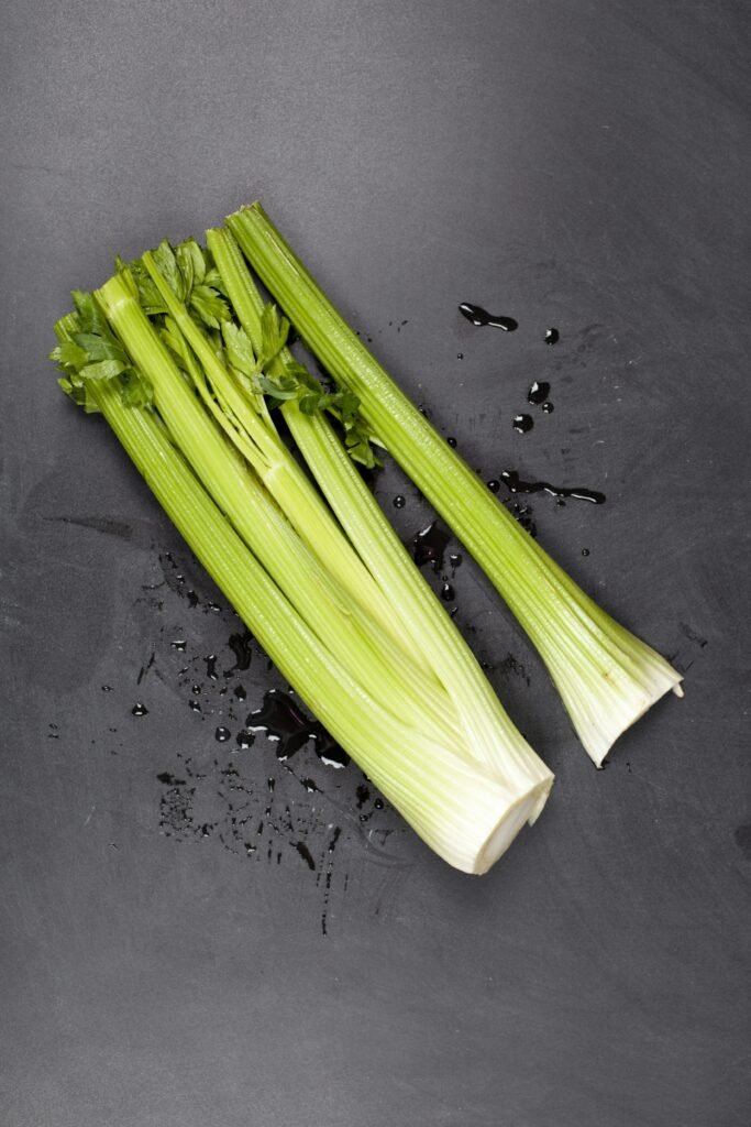 A bunch of celery sitting on top of a table A bunch of celery sitting on top of a table