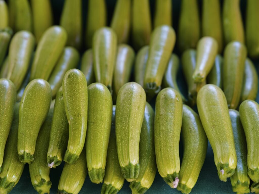 a bunch of green cucumbers sitting next to each other kann man zucchini roh essen