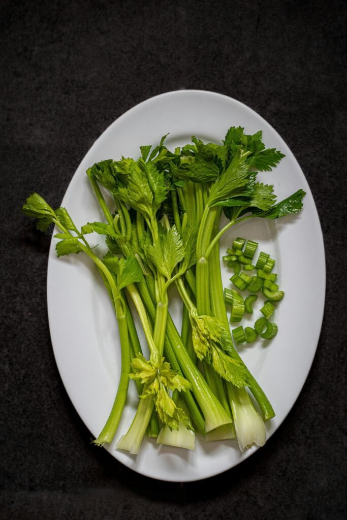 a white plate topped with green vegetables on top of a table a white plate topped with green vegetables on top of a table